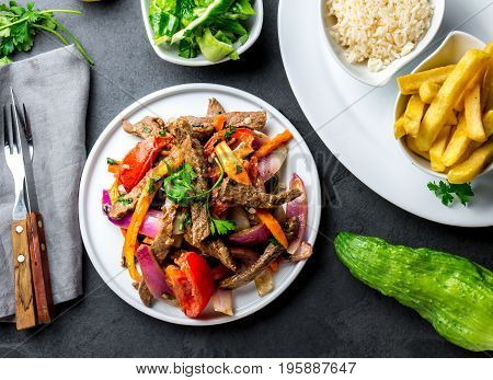 Peruvian Dish Lomo Saltado - Beef Tenderloin With Purple Onion, Yellow Chili, Tomatoes Served On Whi