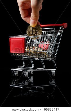 hand throws a bitcoin into trolley.