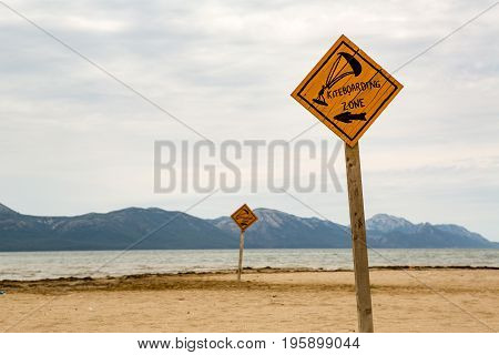 Kiteboarding sign wooden kitesurfing signpost on a beach at adriatic sea in Croatia. Inspiring kitesurfer silhouette kite surfing sport and recreation concept.