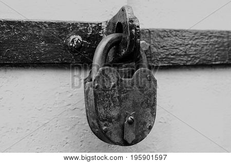 Concept of prohibition or protection. Large antique castle on the iron door. Black and white toning