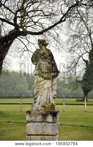 statue covered in moss in a park France