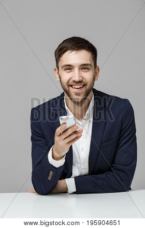 Business Concept - Portrait handsome happy handsome business man in suit playing moblie phone and smiling with laptop at work office. White Background.