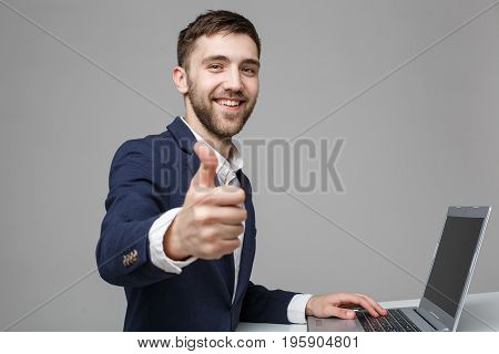 Business Concept - Portrait Handsome Business man showing thump up and smiling confident face in front of his laptop. White Background.Copy Space.