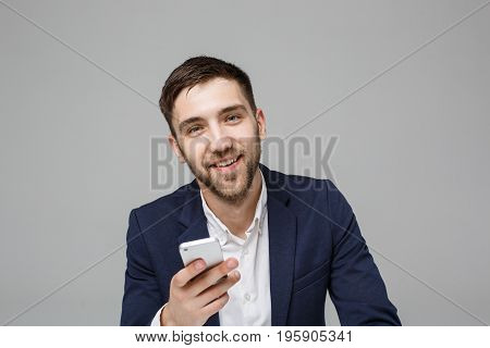 Business Concept - Portrait handsome happy handsome business man in suit playing moblie phone and smiling with laptop at work office. White Background.