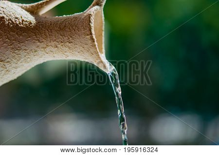 Abstract background. Water flows like a stream of light ceramic jug. The concept of ecology, the value of water