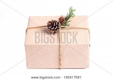 Brown Paper Craft Warped On Present Box Decorate With Pine Cone And Green Leaf Isolated On White Bac