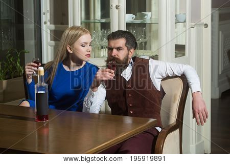Girl And Man Sharing Bottle Of Red Wine In Restaurant