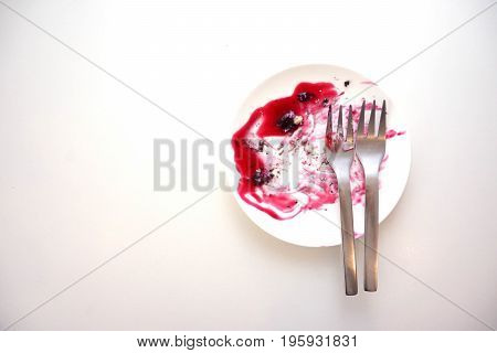 Dirty dishes of blueberry cake after eaten with  fork on white background.
copy space.