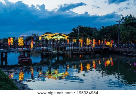 Hoi An city lights and the Thu Bon River in Vietnam at night.