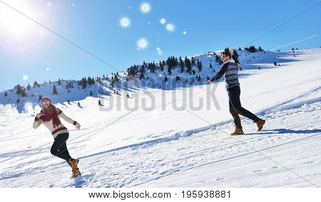 Cheerful young couple having fun in winter park.
