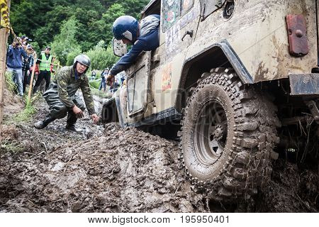 LUBOTIN UKRAINE - JULY 23 2016: RFC Ukraine Wild Boar Challenge 2016. Team on Uaz 469 setting a recovery sand tracks to overcome a hard pit.