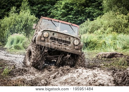 LUBOTIN UKRAINE - JULY 23 2016: RFC Ukraine Wild Boar Challenge 2016. Custom built Off-road Trophy UAZ 469 passing mud pit.