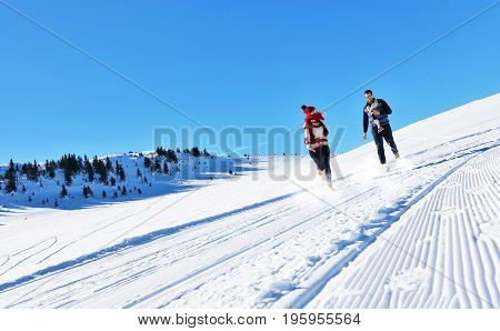 Cheerful young couple having fun in winter park.