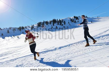 Cheerful young couple having fun in winter park.