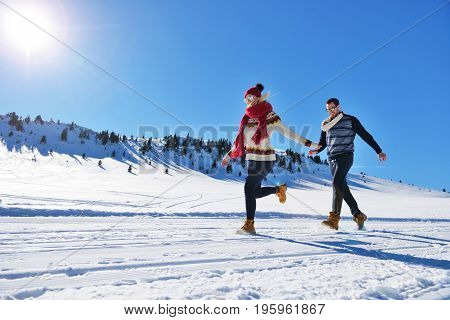 Cheerful young couple having fun in winter park.