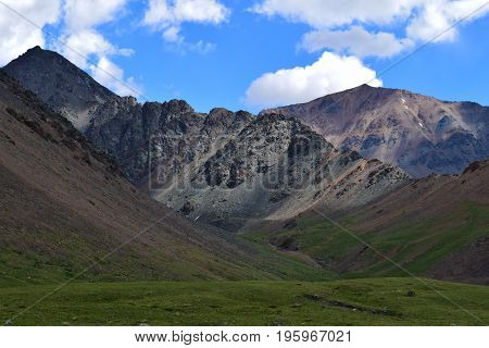 View of ravine blue sky and green meadow in Altai mountains. Altay Republic Siberia Russia.