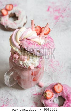 Pink strawberry freakshake milkshake with sweets donut and marshmallow