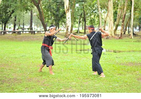 PUKED,THAILAND - AUGUST 28: Master trick of ancient fighter on August 28, 2011 in Puked Thailand.
 Master show how to trick of fight with swords.