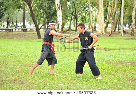 PUKED,THAILAND - AUGUST 28: Master trick of ancient fighter on August 28, 2011 in Puked Thailand.
 Master show how to trick of fight with swords.