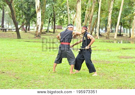 PUKED,THAILAND - AUGUST 28: Master trick of ancient fighter on August 28, 2011 in Puked Thailand.
 Master show how to trick of fight with swords.