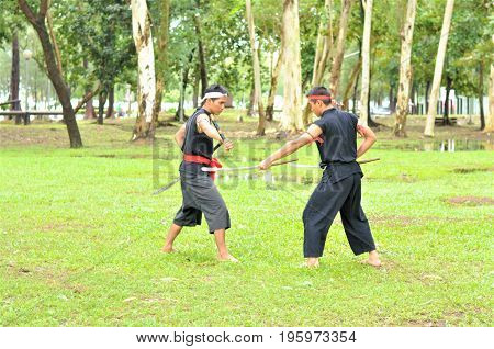 PUKED,THAILAND - AUGUST 28: Master trick of ancient fighter on August 28, 2011 in Puked Thailand.
 Master show how to trick of fight with swords.