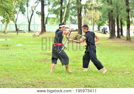 PUKED,THAILAND - AUGUST 28: Master trick of ancient fighter on August 28, 2011 in Puked Thailand.
 Master show how to trick of fight with swords.
