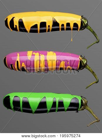Three Eggplants With Pouring Toxic Green, Yellow And Purple Yellow Paint On Gray Background. Fashion