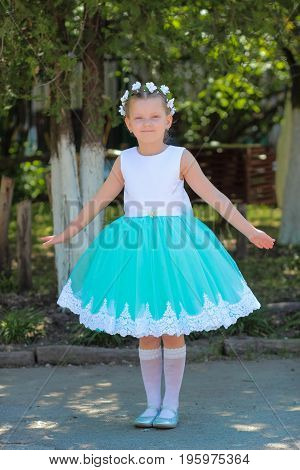 Beautiful Little Girl In Dress Standing And Posing Over Nature Background, Child With A Wreath Of Ar