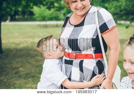 Grandmother playing in the park with grandchildren, siter with brother