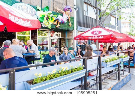 Montreal Canada - May 27 2017: People sitting in restaurant at table in outside seating area in Gay Village neighborhood in city in Quebec region