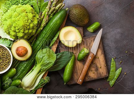 Assorted Green Toned Raw Organic Vegetables In Wooden Box On Dark Stone Background. Avocado, Cabbage