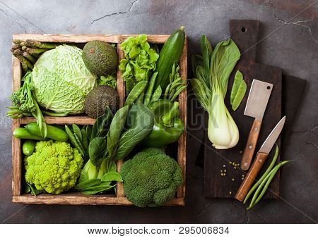 Assorted Green Toned Raw Organic Vegetables In Wooden Box On Dark Stone Background. Avocado, Cabbage