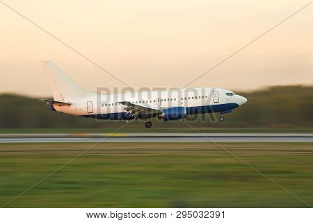 Narrow-body Passenger Airliner Landing At International Airport During Sunset, In Motion, Side View,
