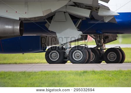 Close Up High Detailed View On Main Landing Gear Of Passenger Airplane Taxing On Runway/ Close Up Of