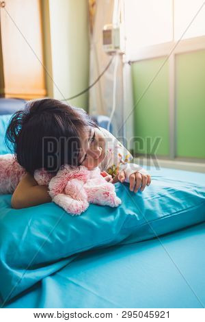 Illness Asian Child Admitted In Hospital While Saline Intravenous (iv) On Hand. Unhappy Girl Depress