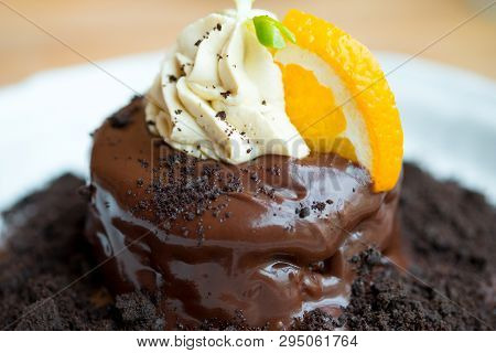 Chocolate Fondant And Orange Slice With Whip Cream Dcoration On Top, Close Up