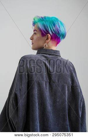 A Young Woman With Short Hair, A Pixie Bob Haircut, Different Colored Hair, Blue, Green, Violet.