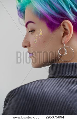 A Young Woman With Short Hair, A Pixie Bob Haircut, Different Colored Hair, Blue, Green, Violet.
