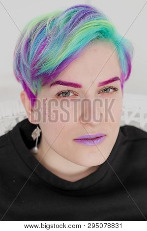 A Young Woman With Short Hair, A Pixie Bob Haircut, Different Colored Hair, Blue, Green, Violet.