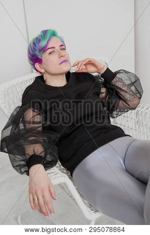 A Young Woman With Short Hair, A Pixie Bob Haircut, Different Colored Hair, Blue, Green, Violet.