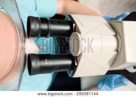 Woman Laborant Working With Microscope Holding Automatic Pipette