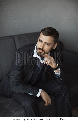 Modern Businessman. Confident Young Man In A Trendy Suit Looking At The Camera While Sitting Indoors