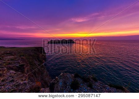 Ship Sails On A Background Of Purple Sunset Sky On The Waves Of Lake Baikal From Olkhon