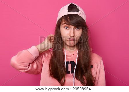 Young Cute Girl In Casual Clothes Rose Hoodie And Visor Cap Back, Posing On Pink Background Looking 