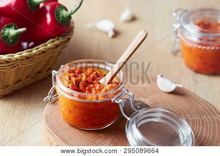 Roasted red pepper relish (Ajvar) in a jar with ingredients