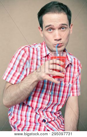 Confused Thoughtful Blue-eyed Hipster Boy Drinking Over Wooden Background