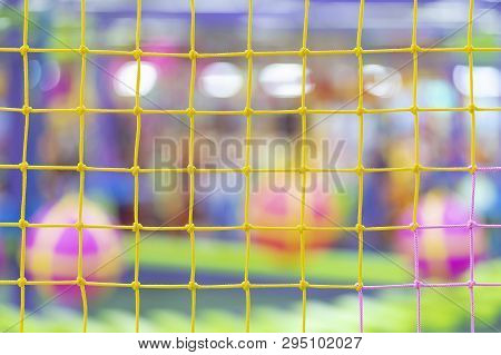 Multi-colored Grid On The Background Of A Blurred Playground With Balls And Mazes