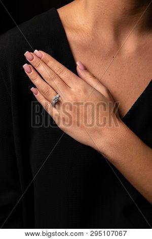 Womens Silver Diamonds Ring In The Shape Of A Square With A Fringe On Finger, On A Black Background.