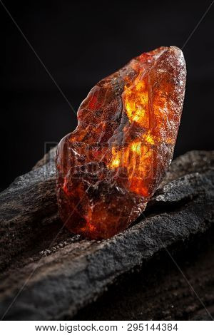 Natural Amber. A Piece Of Yellow And Red Semi Transparent Natural Amber On Piece Of Stoned Wood.