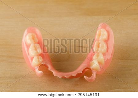 Large Image Of A Modern Denture On A Wooden Background